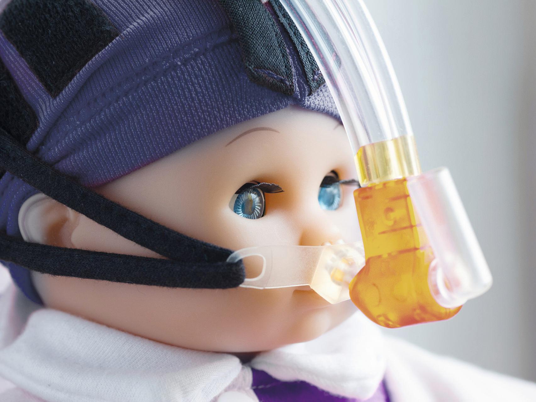Vista ampliada do rosto de uma boneca usando uma máscara respiratória.