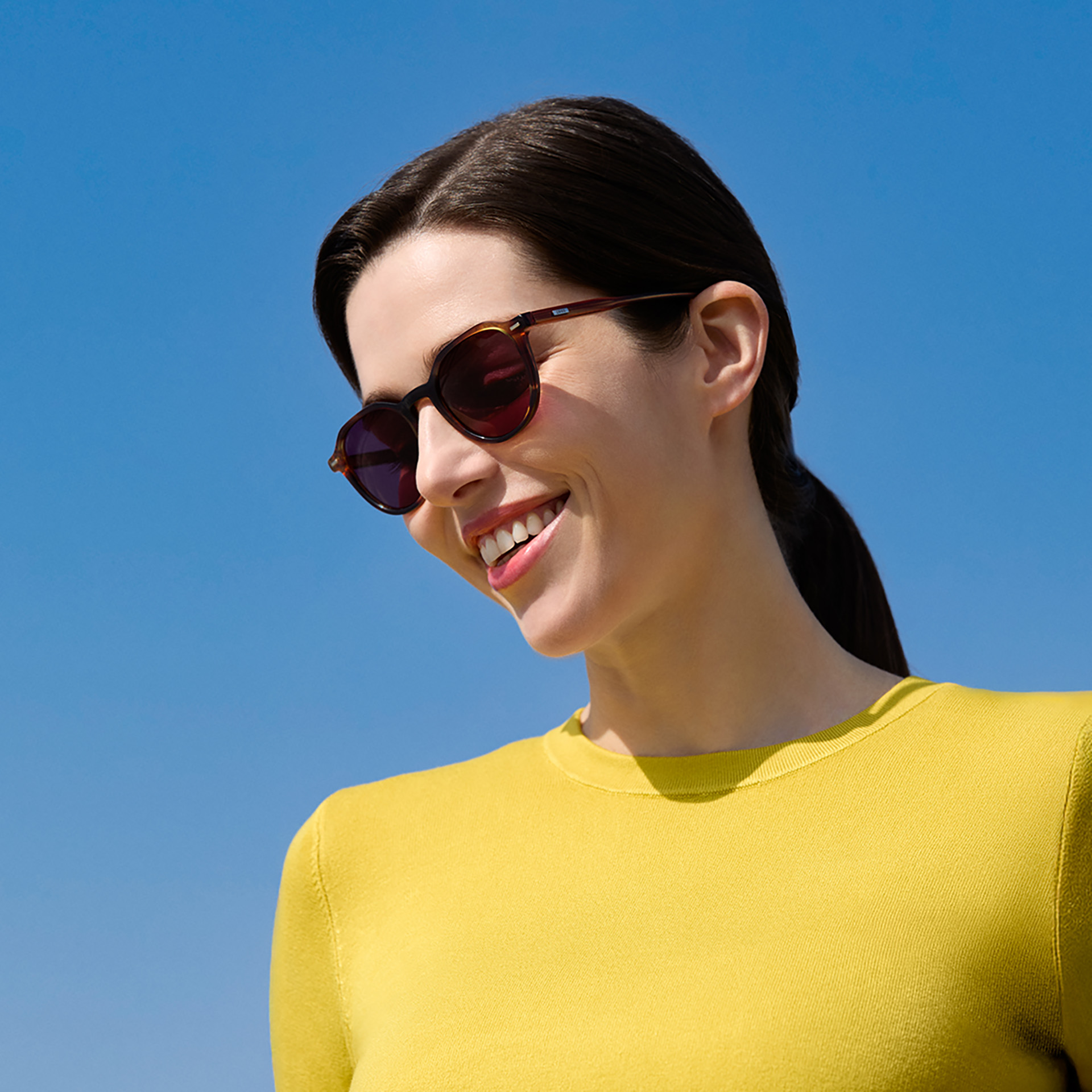 Mulher usando lentes para óculos de sol de grau na tonalidade Burgundy.