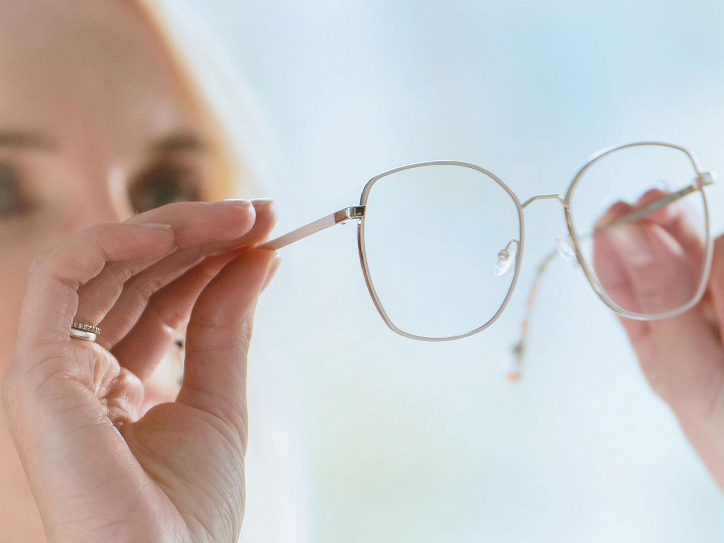 Uma mulher observando a parte interna dos óculos
