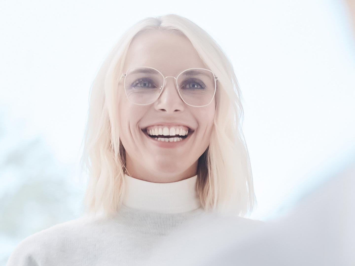 Uma mulher sorridente de óculos 