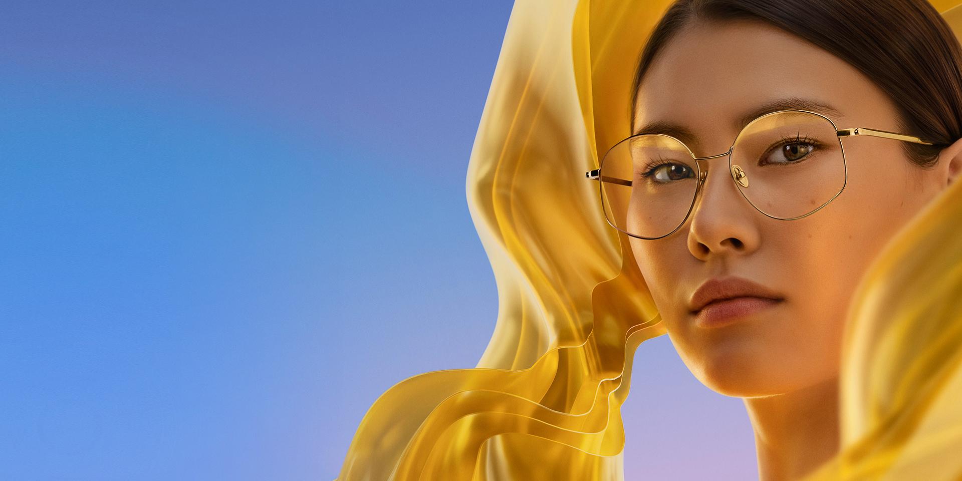 Mulher usando óculos incolores com ZEISS DuraVision Gold UV, que confere à lente um reflexo dourado sutil, porém distinto.