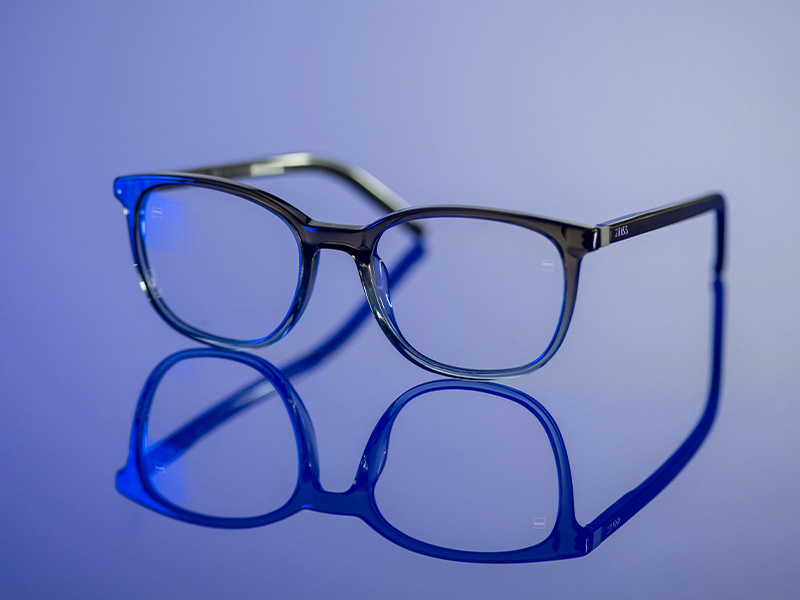 Óculos incolores sobre uma superfície azul brilhante.