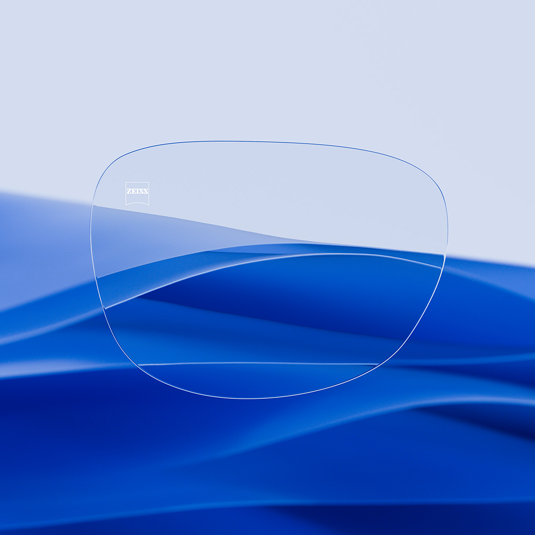 Uma lente de óculos dividida ao meio, com um lado nítido e limpo com ZEISS DuraVision e um lado coberto de riscos.
