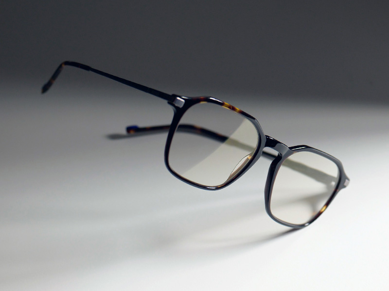 Imagem de óculos incolores em uma armação marrom com o leve tom dourado do ZEISS DuraVision Gold UV.