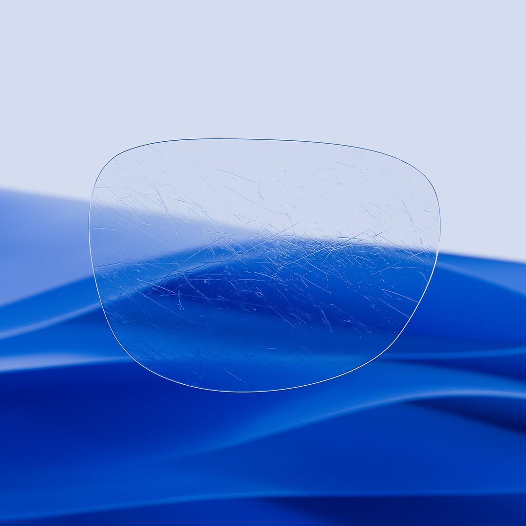 Uma lente de óculos dividida ao meio, com um lado nítido e limpo com ZEISS DuraVision e um lado coberto de riscos.