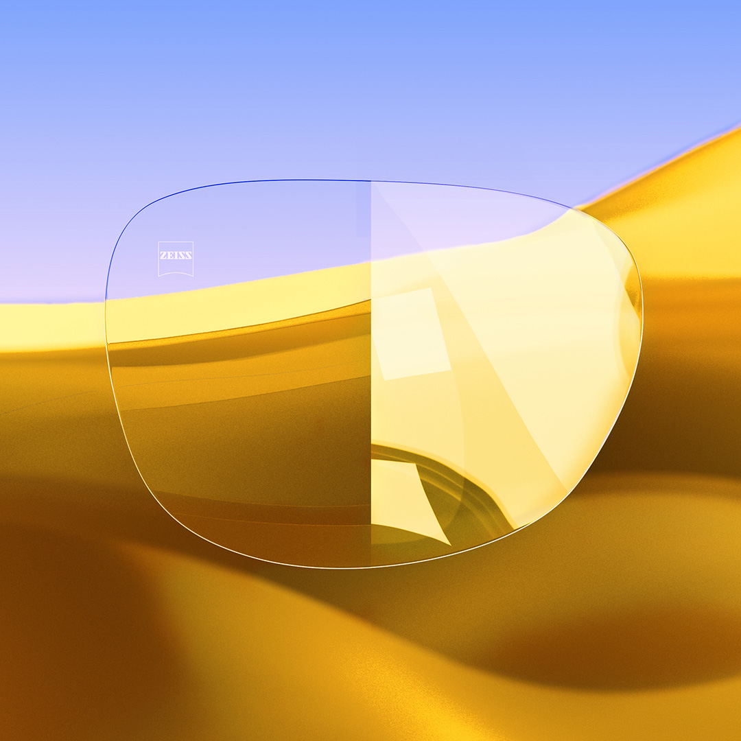 Uma lente dividida ao meio, com um lado nítido e limpo com ZEISS DuraVision Gold e um lado exibindo reflexos intensos de luz sobre a lente. 