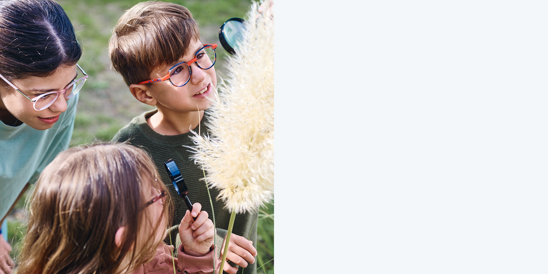 2 meninas e 1 menino com lentes ZEISS MyoCare. Três crianças olham para uma planta, duas a observam através de lupas.