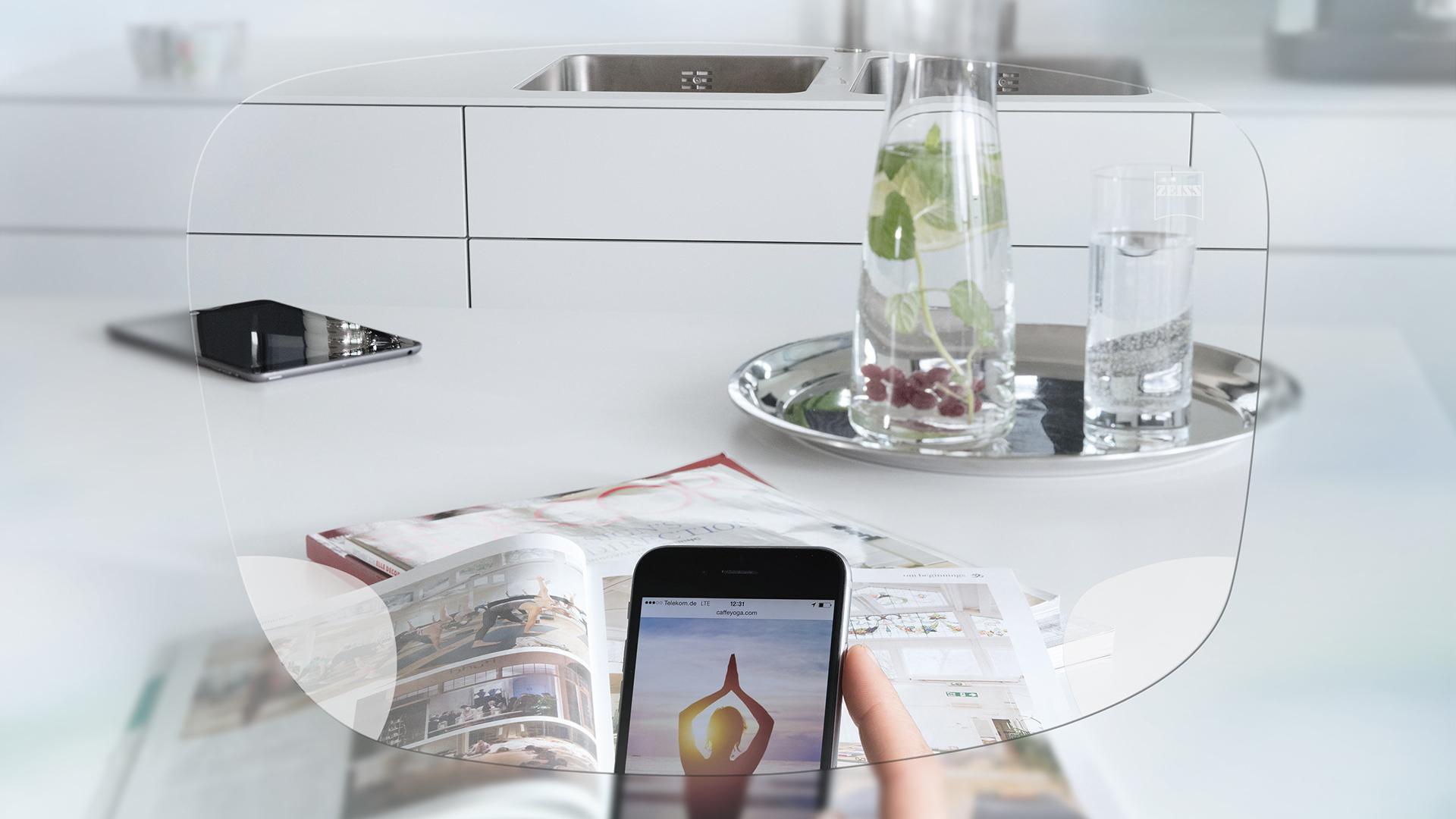 Visão através das lentes de visão simples ZEISS EnergizeMe de uma tela do smartphone e de uma bancada de cozinha organizada. 