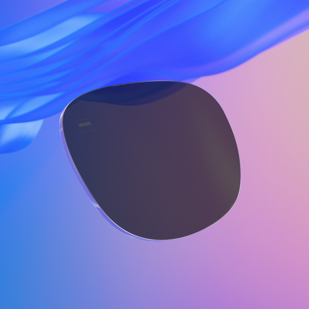 Imagem deslizante cuja metade mostra uma lente de óculos de sol de grau ZEISS intensamente colorida e a outra metade mostra a mesma lente, porém menos intensamente colorida.