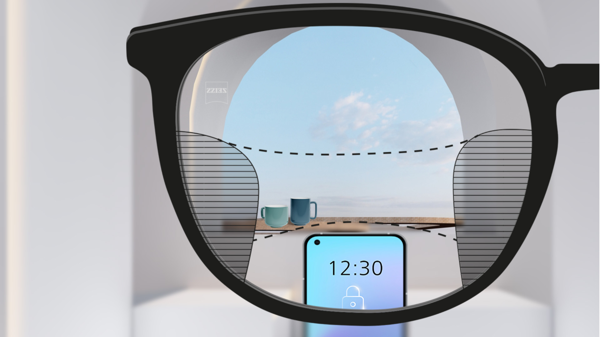 Imagem do ponto de vista de lentes ZEISS Progressivas SmartLife com um smartphone e xícaras em segundo plano enquanto a lente está totalmente transparente, mas com linhas finas borradas à direita e à esquerda.