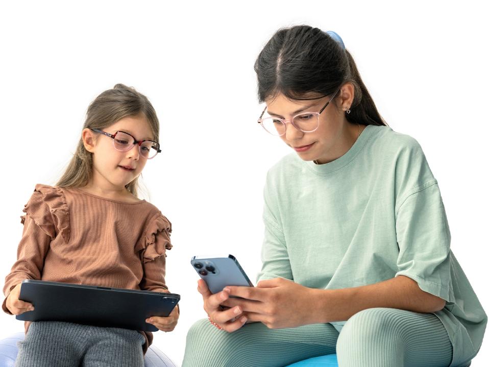 Duas meninas olhando para dispositivos digitais à distância sugerida de mais de 20 cm.