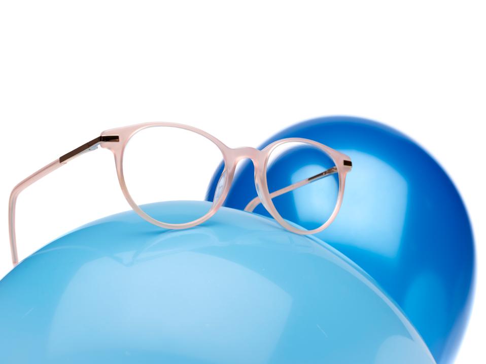 Lentes ZEISS MyoCare em uma armação bege rosada são mostradas em um balão azul claro.