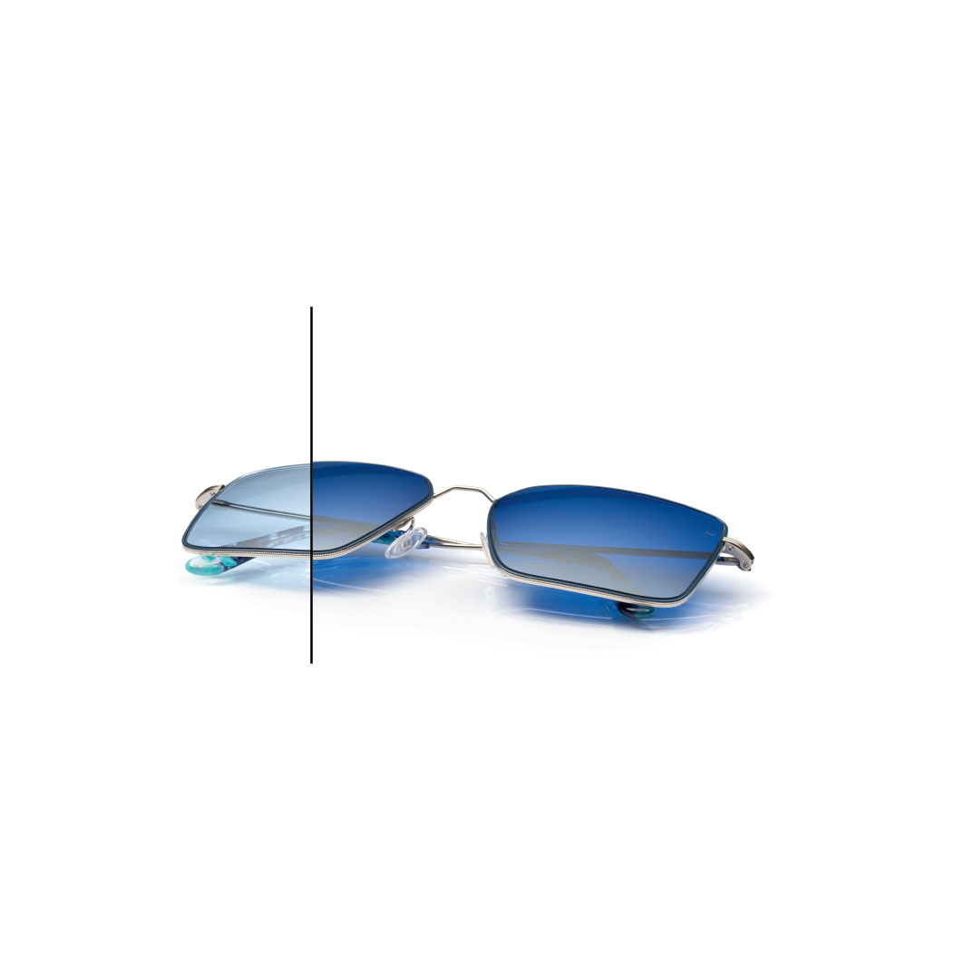 Óculos com lentes ZEISS PhotoFusion X azuis com revestimento espelhado ZEISS DuraVision Flash cor Diamond. A metade de uma das lentes não está totalmente escurecida para mostrar a diferença de cor.