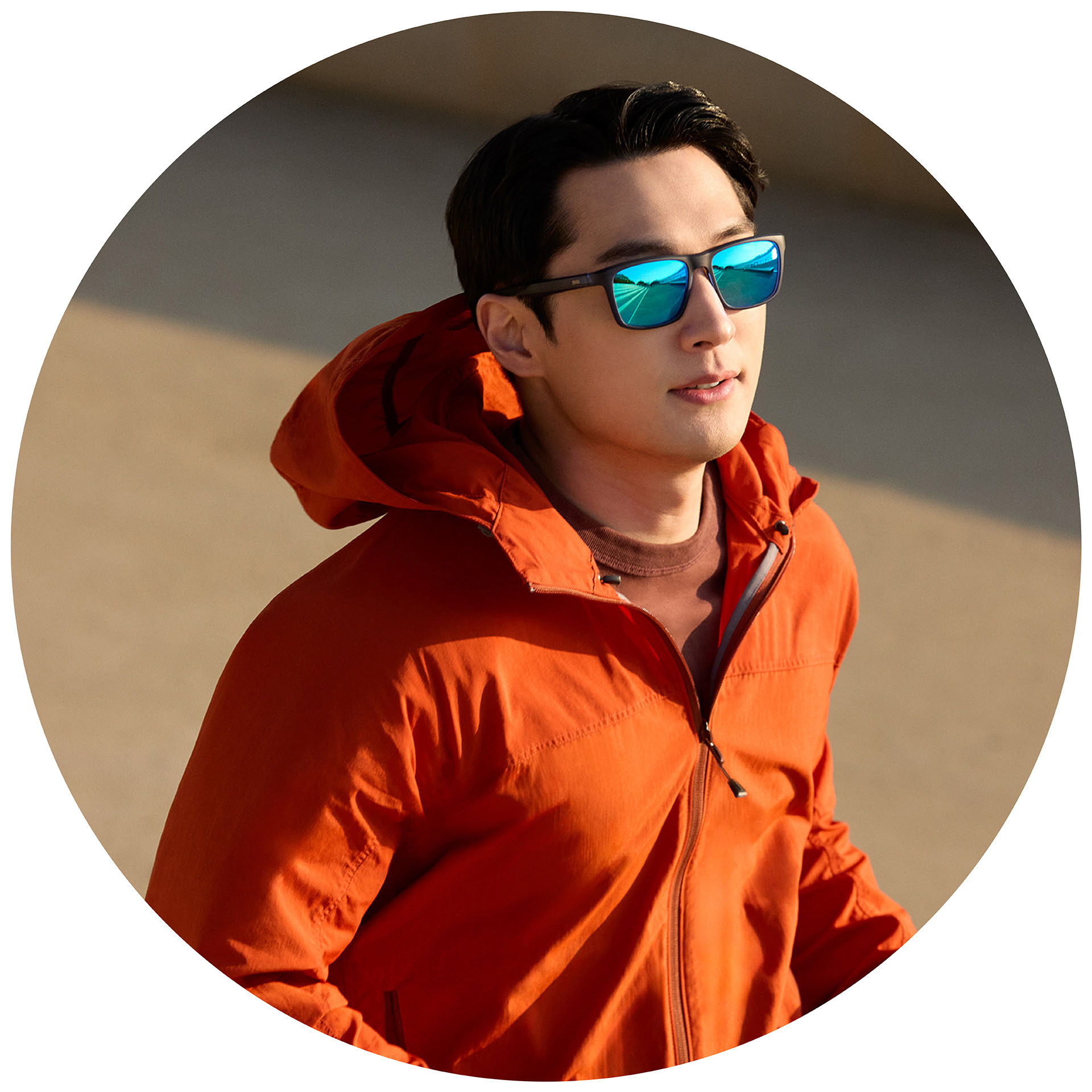 Uma pessoa correndo com uma jaqueta laranja usando óculos de sol de grau ZEISS com um tratamento espelhado azul.