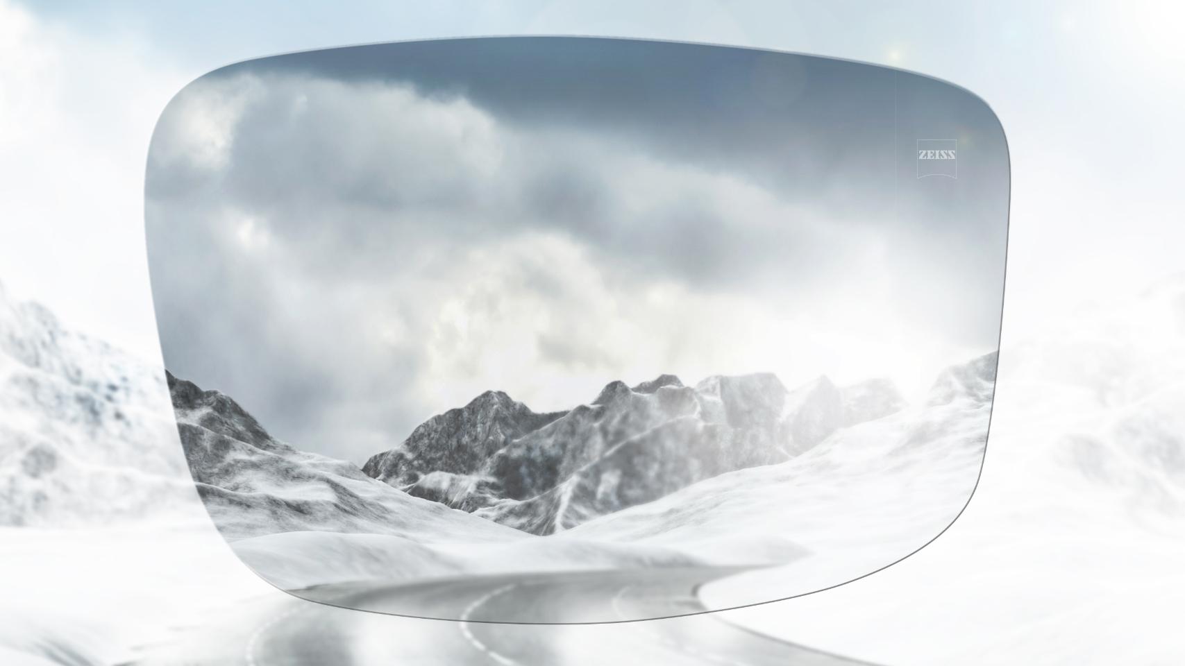 Vista de uma estrada em uma montanha coberta de neve com e sem óculos polarizados. Com óculos de sol polarizados, o ofuscamento é reduzido e a visão fica muito mais nítida.