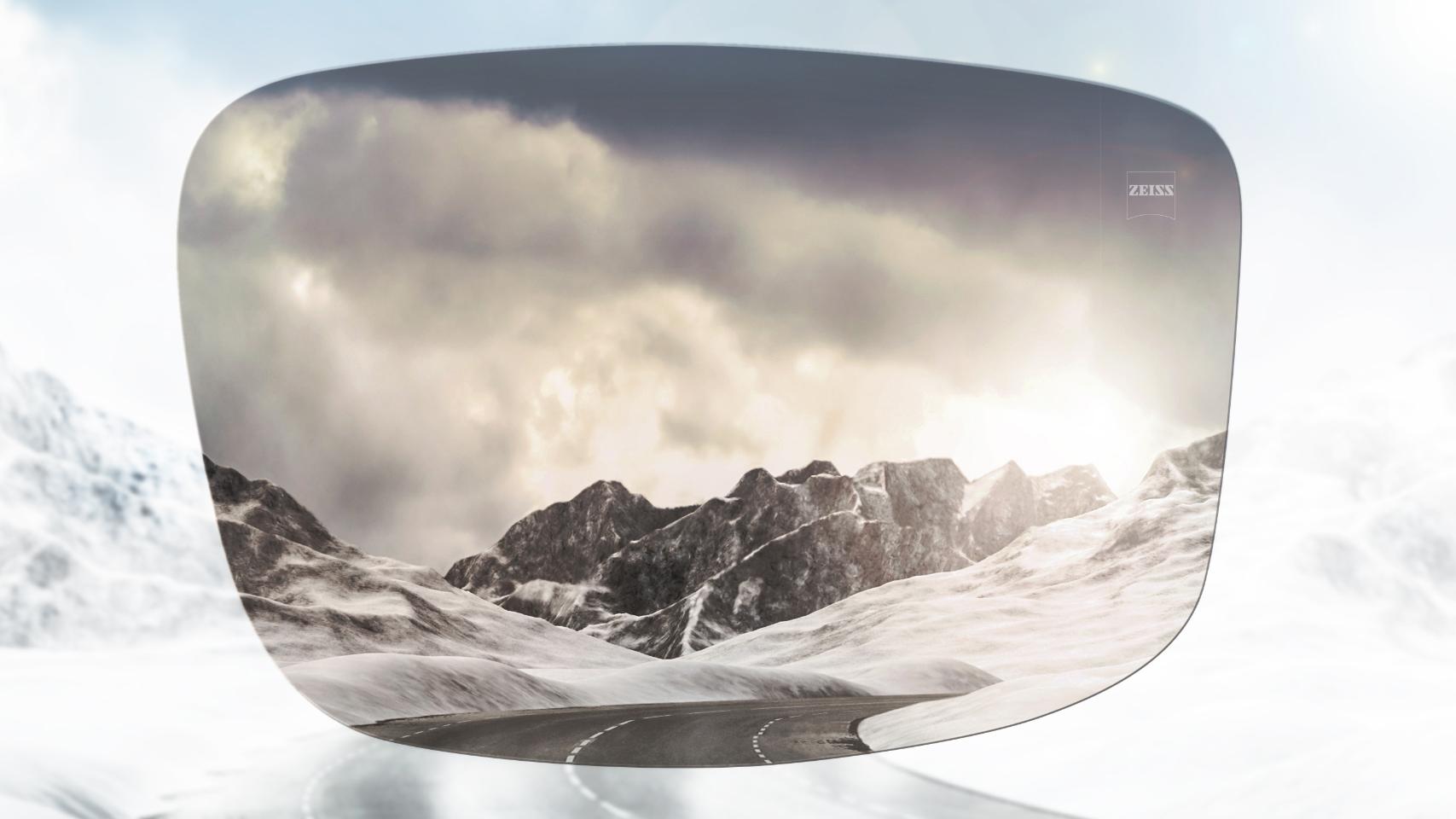 Vista de uma estrada em uma montanha coberta de neve com e sem óculos polarizados. Com óculos de sol polarizados, o ofuscamento é reduzido e a visão fica muito mais nítida.