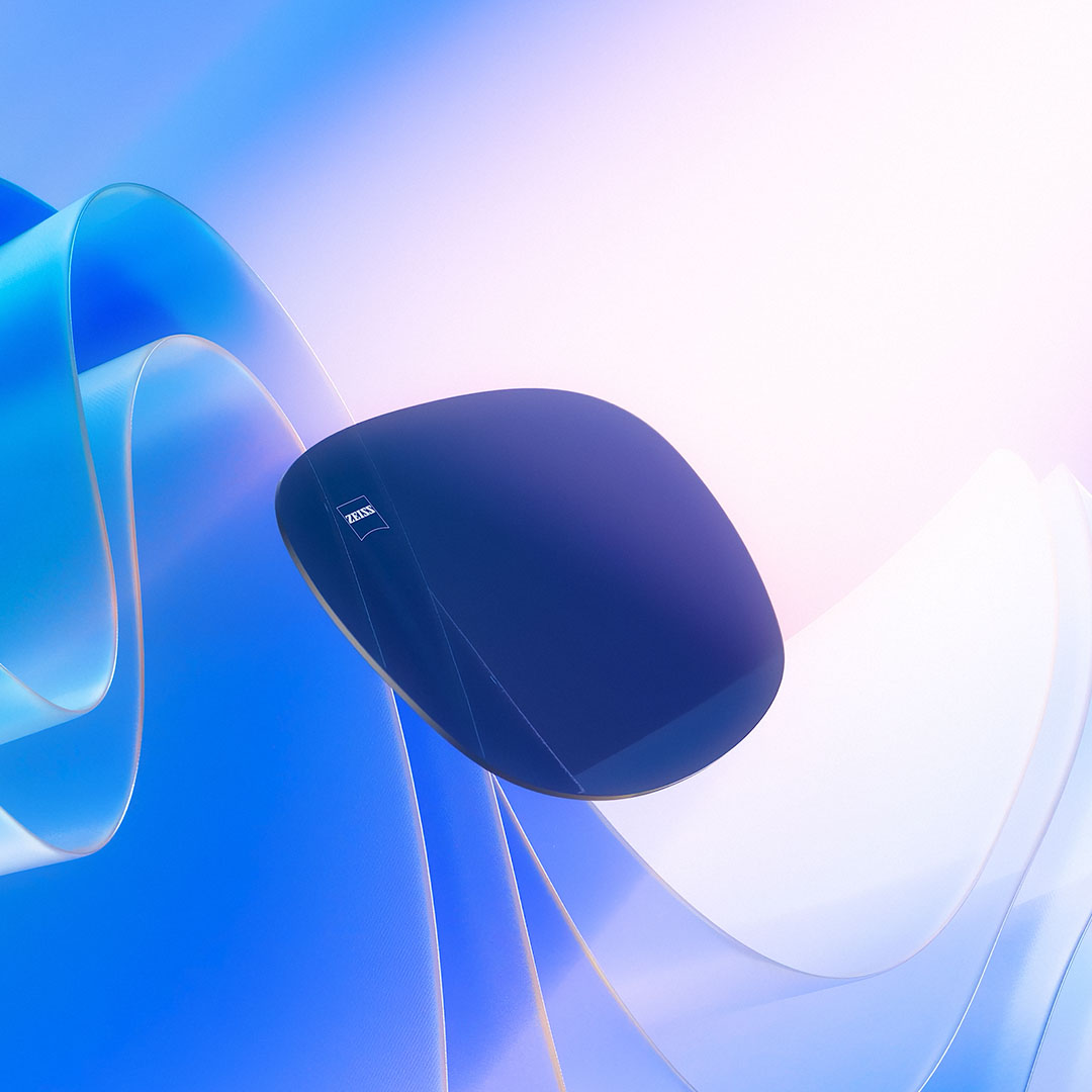 Uma representação em CGI de uma lente colorida é mostrada flutuando em direção à luz do sol, ilustrando sua capacidade de bloqueio dos raios UV