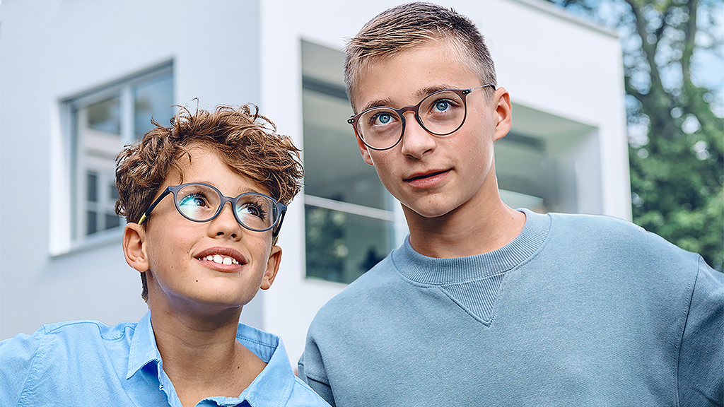 Menino olhando para um adolescente, ambos usando óculos de visão simples ZEISS SmartLife Young